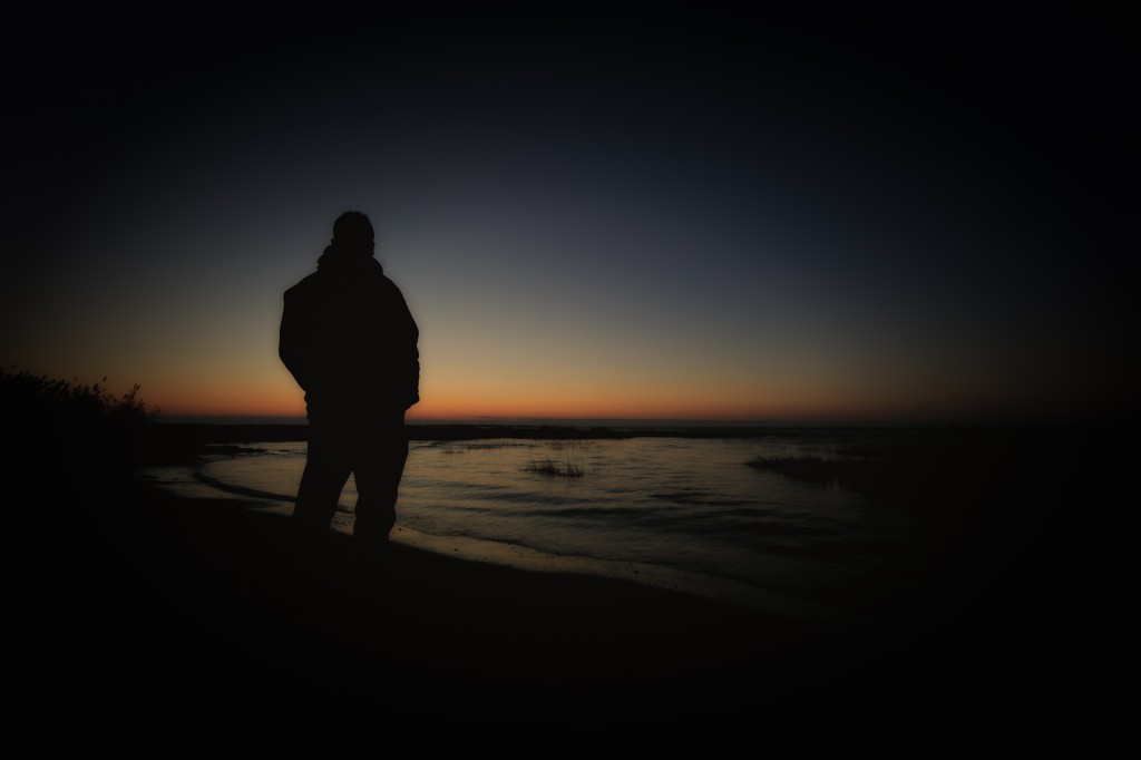 A silhouette self-portrait of Greg Molyneux watching a late Fall sunrise