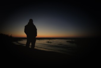A silhouette self-portrait of Greg Molyneux watching a late Fall sunrise