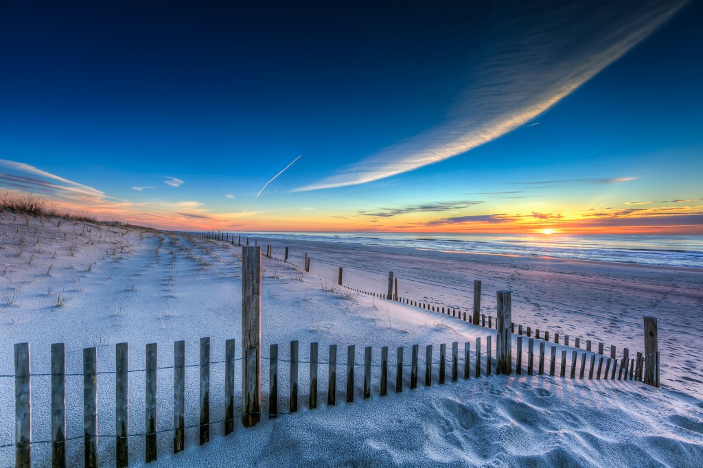 An HDR sunrise photograph overlooking the dunes, dune fence, ocean and sand of 13th Street in Ship Bottom, NJ.