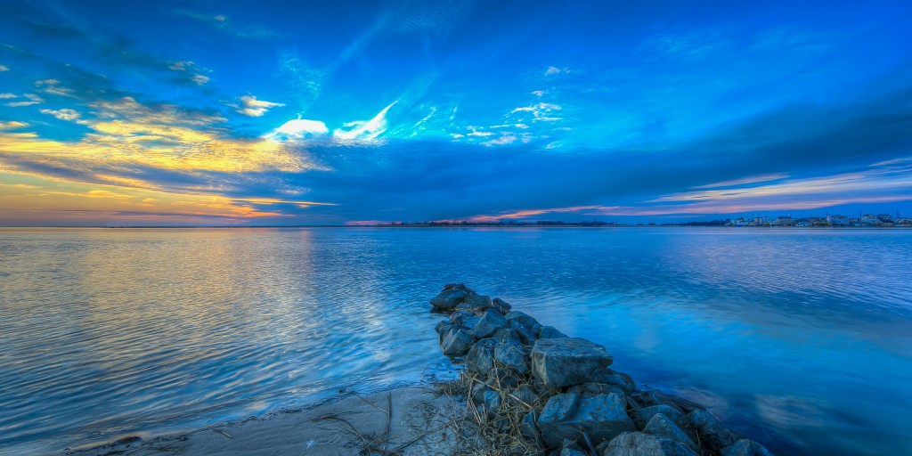 An HDR photograph taken just before sunset from the north end of the bay beach in Ship Bottom, New Jersey. The protruding jetty rock creates a natural leading line toward the drama off on the horizon.