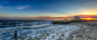 An HDR photograph taken at sunset from the east end of Cedar Run Dock Road. Rolling waves from Barnegat Bay move onshore leaving heavy foam upon the small shell-laden beachfront.