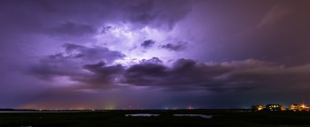 Long exposure lightning photography taken from Cedar Run Dock Road. Cloud to cloud lightning ignites the sky in an electrified purple glow.