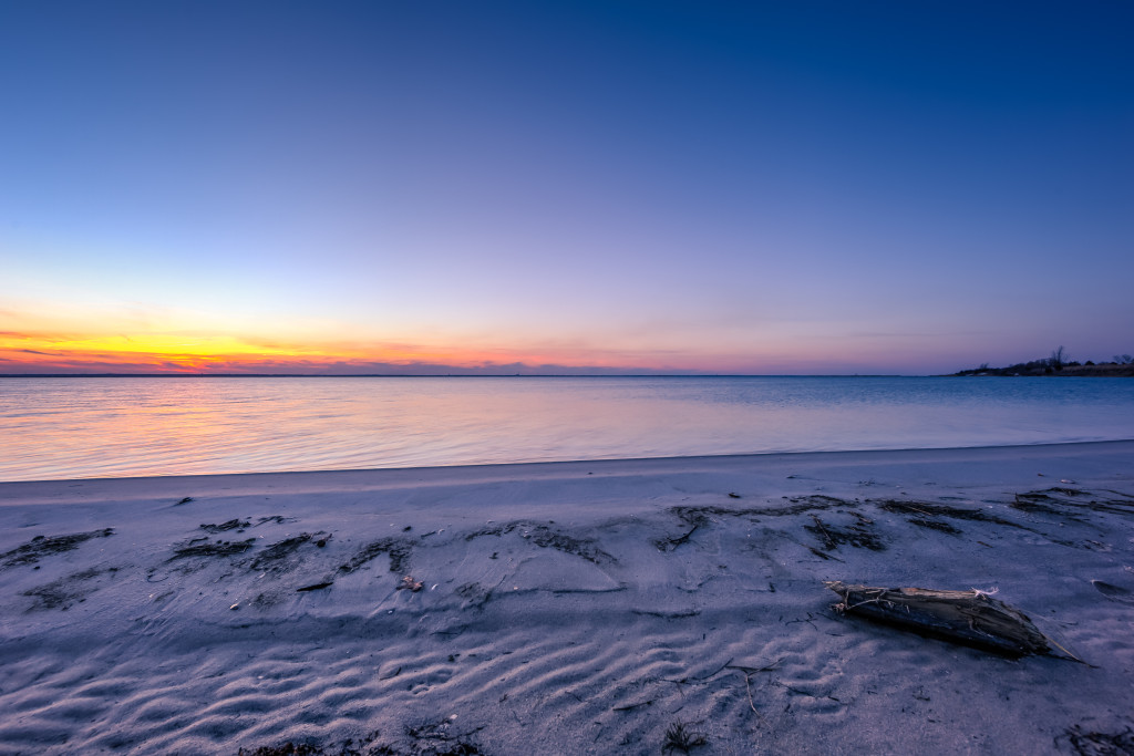 A serene blue hour befalls a calm Barnegat Bay in this wide angle HDR photograph taken from the secluded shores of High Bar Harbor, Long Beach Island, New Jersey.