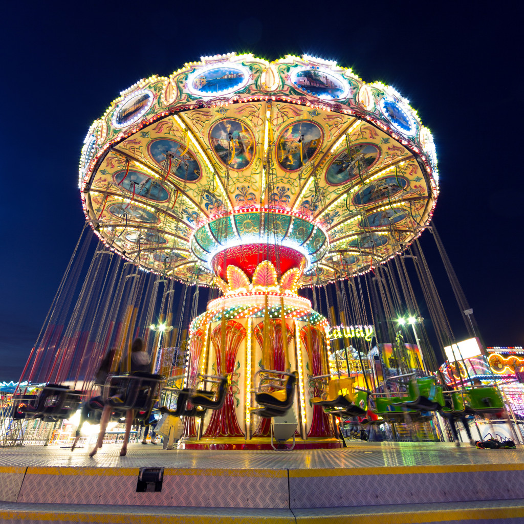 A blue hour long exposure square format wide angle photograph of Wave Swinger; a carnival swing captured at rest at Casino Pier, Seaside Heights, New Jersey.