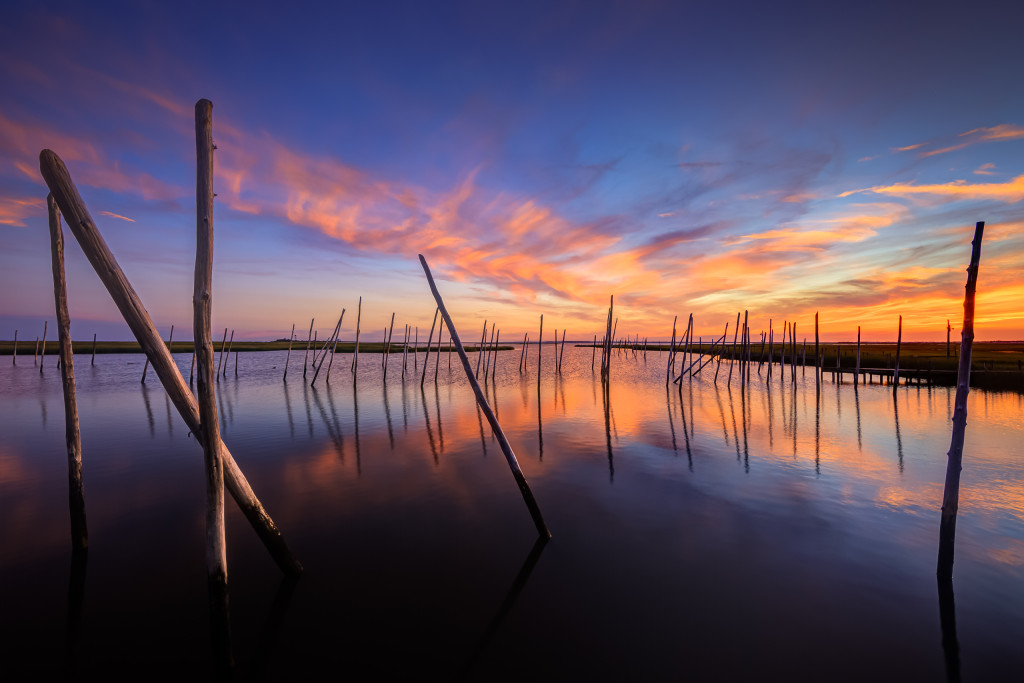 Wide angle HDR photograph of an abandoned marina and a reflective sunset on Great Bay