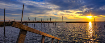 Square format HDR landscape photograph of dock and bay at sunset
