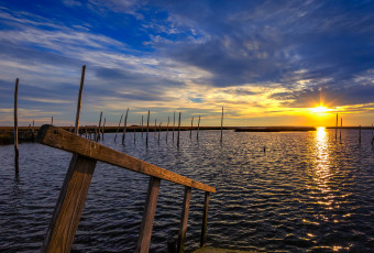 Square format HDR landscape photograph of dock and bay at sunset