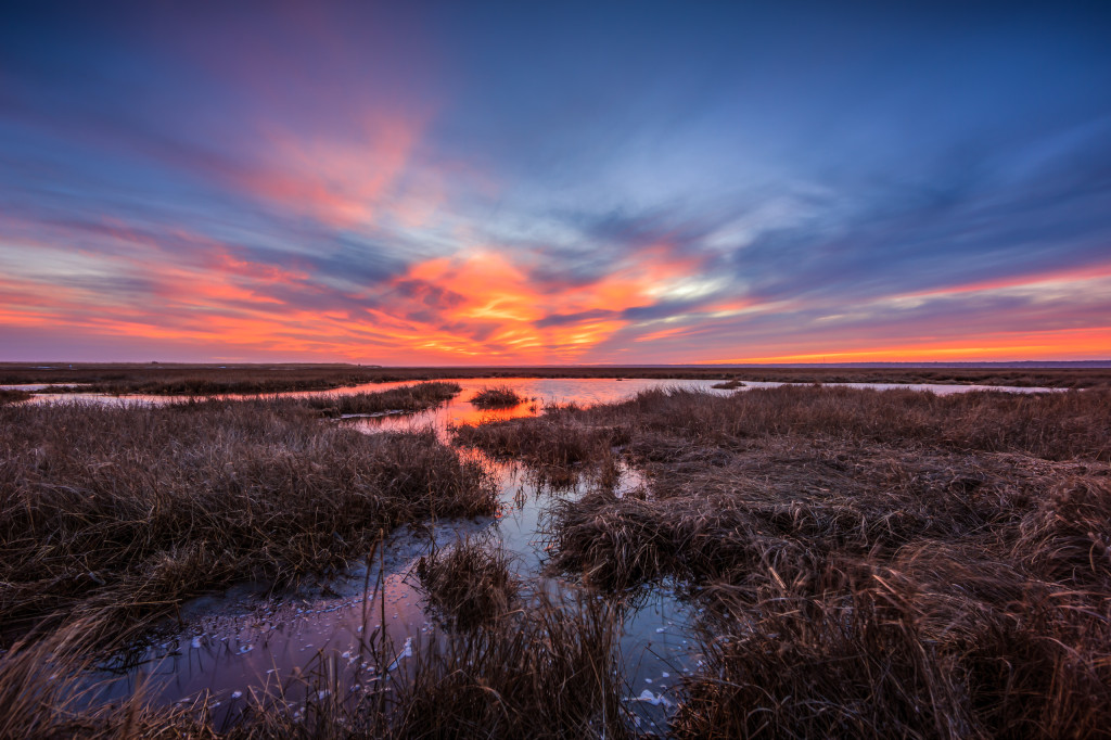 Fiery sunset smolders over the marsh taken as a landscape HDR photograph