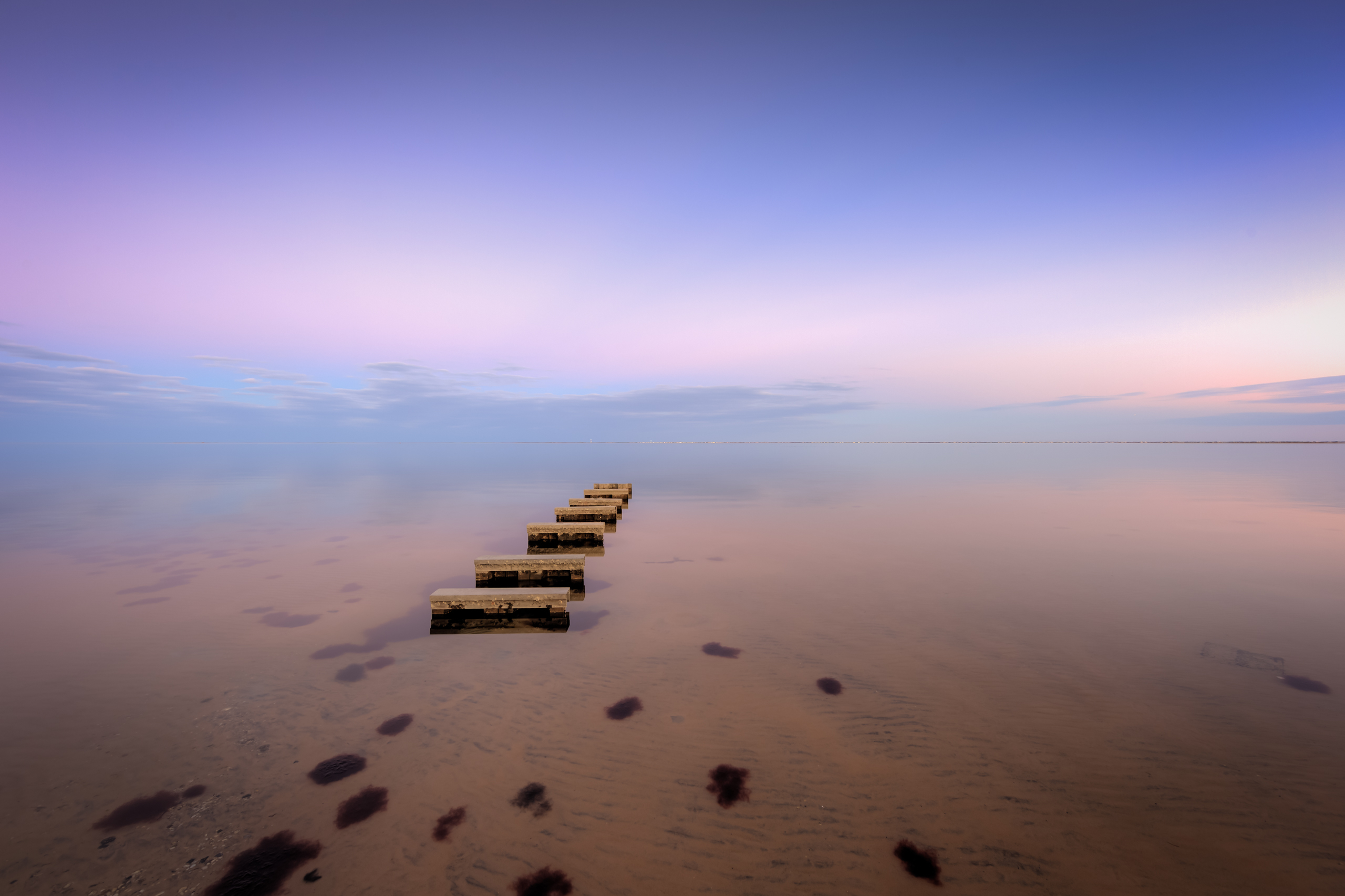 Blue hour photograph of an exposed manmade jetty in Barnegat Bay