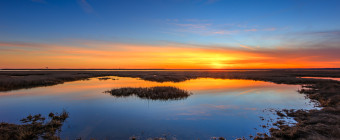 Sunset photograph of a reflective marsh tide pool
