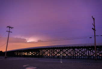 Long exposure photograph of Great Bay Boulevard's first bridge backlit by lightning.