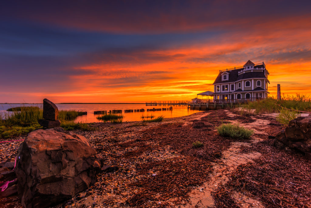 Sunset photograph of stacked stones and dead eelgrass at Antoinetta's Waterfront Restaurant.