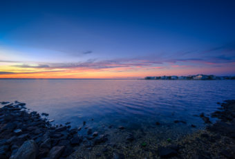 Blue hour photograph of jetty rock shore and Barnegat Bay from Harvey Cedars Sunset Park.
