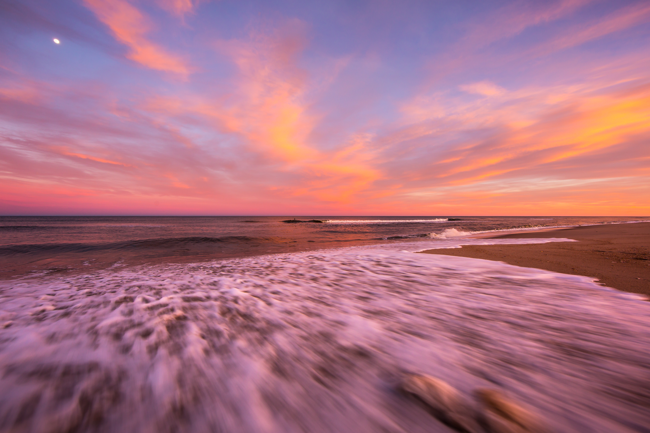 Explosive sunset photo over rushing Atlantic Ocean wash.