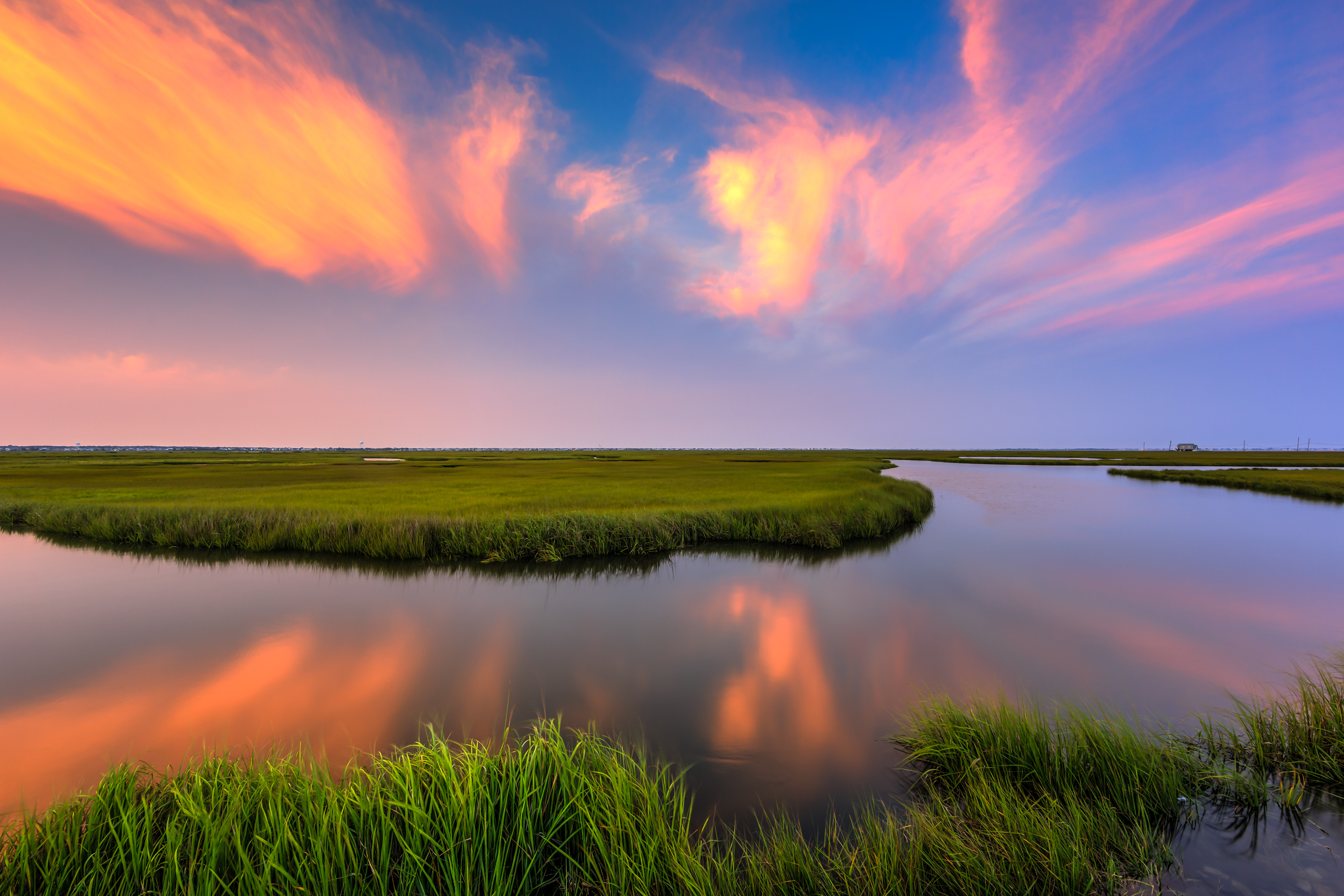 Sunset photo burns over summer salt marsh.