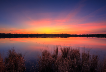 Fiery sunset photo over still water at Stafford Forge Wildlife Management Area.
