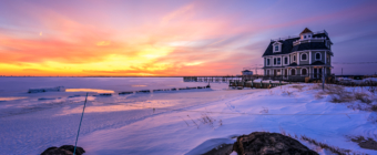Snowy sunset photo of Antoinetta's Restaurant and a frozen bay.