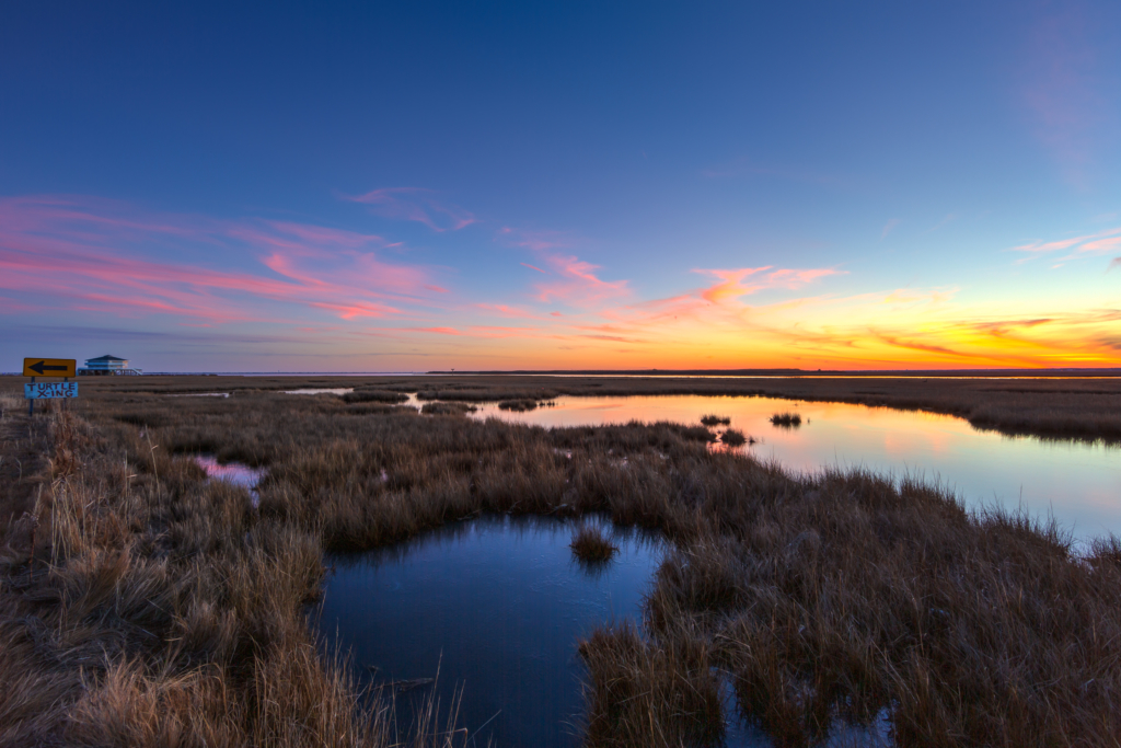Wide angle winter sunset photo made over tranquil salt marsh.