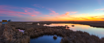 Wide angle winter sunset photo made over tranquil salt marsh.