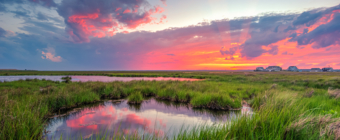 14mm wide angle HDR sunset photo featuring salt marsh, storm clouds, and anticrepuscular rays.