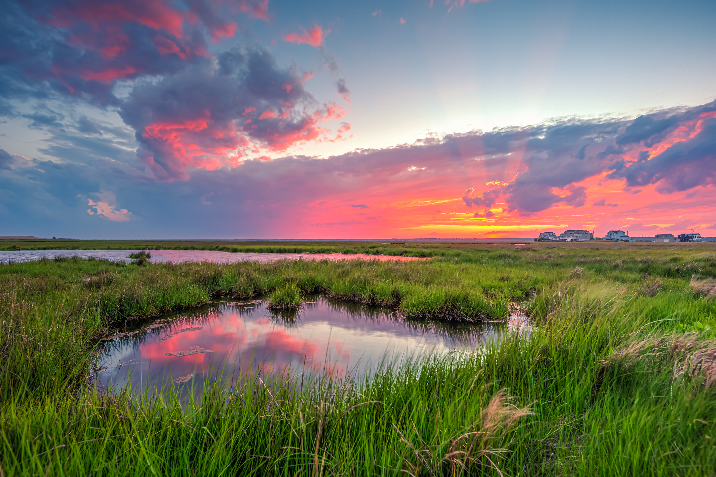 14mm wide angle HDR sunset photo featuring salt marsh, storm clouds, and anticrepuscular rays.