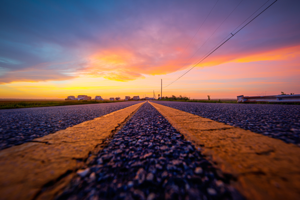 14mm wide angle sunset photo made at street level on an asphalt road surface between double yellow lines.