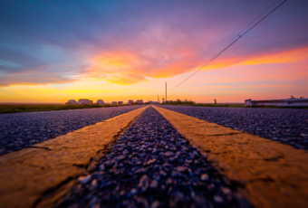 14mm wide angle sunset photo made at street level on an asphalt road surface between double yellow lines.