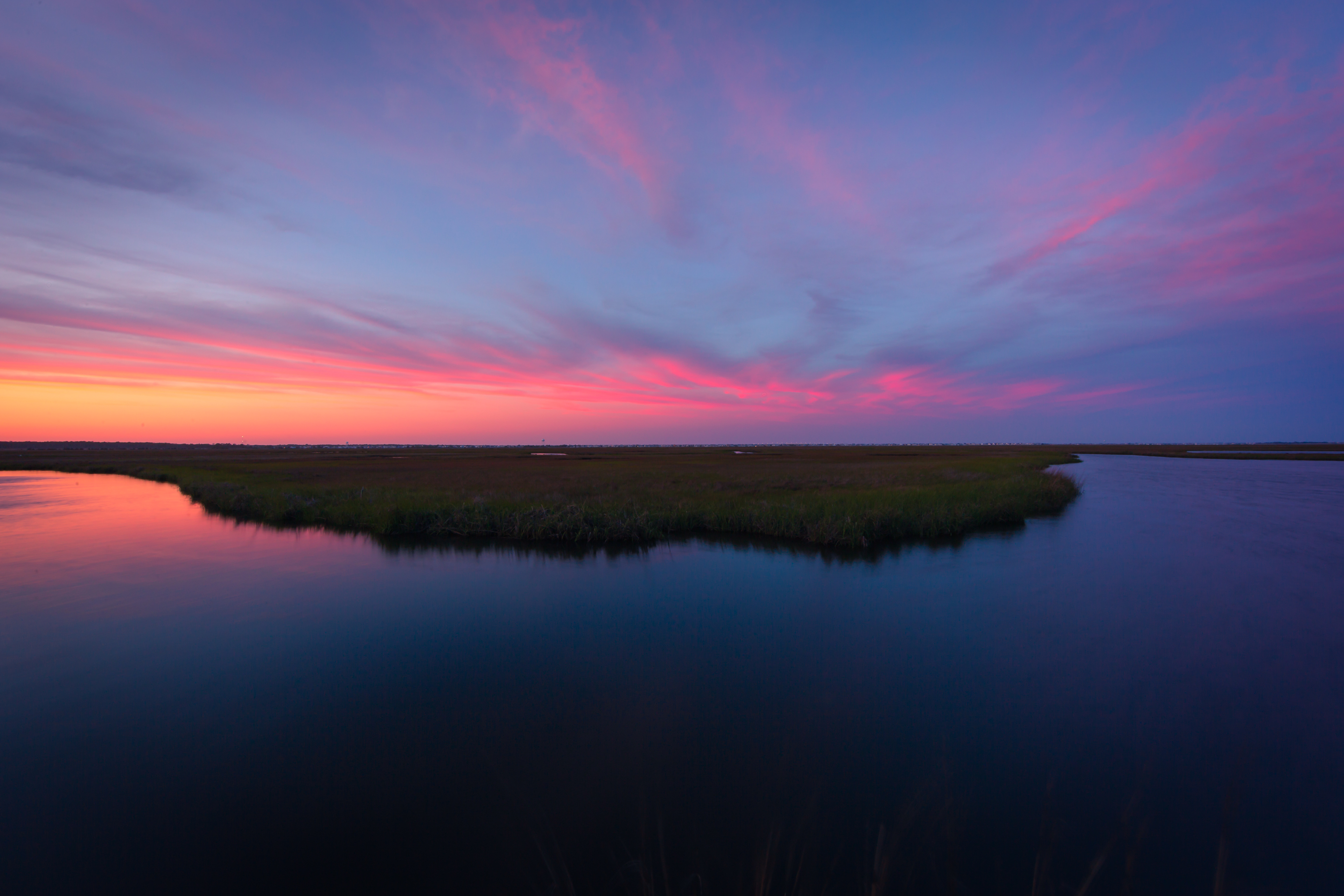 14mm wide angle landscape photo made low key at blue hour. Soft pastels color up the sky above an oxbow lake feature of the Cedar Run Dock Road salt marsh.