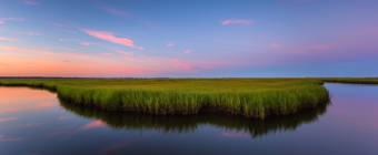 14mm wide angle photograph of a salt marsh oxbow feature at blue hour. Mirrored reflection captures the still colored pastel clouds stretched thin across the sky.
