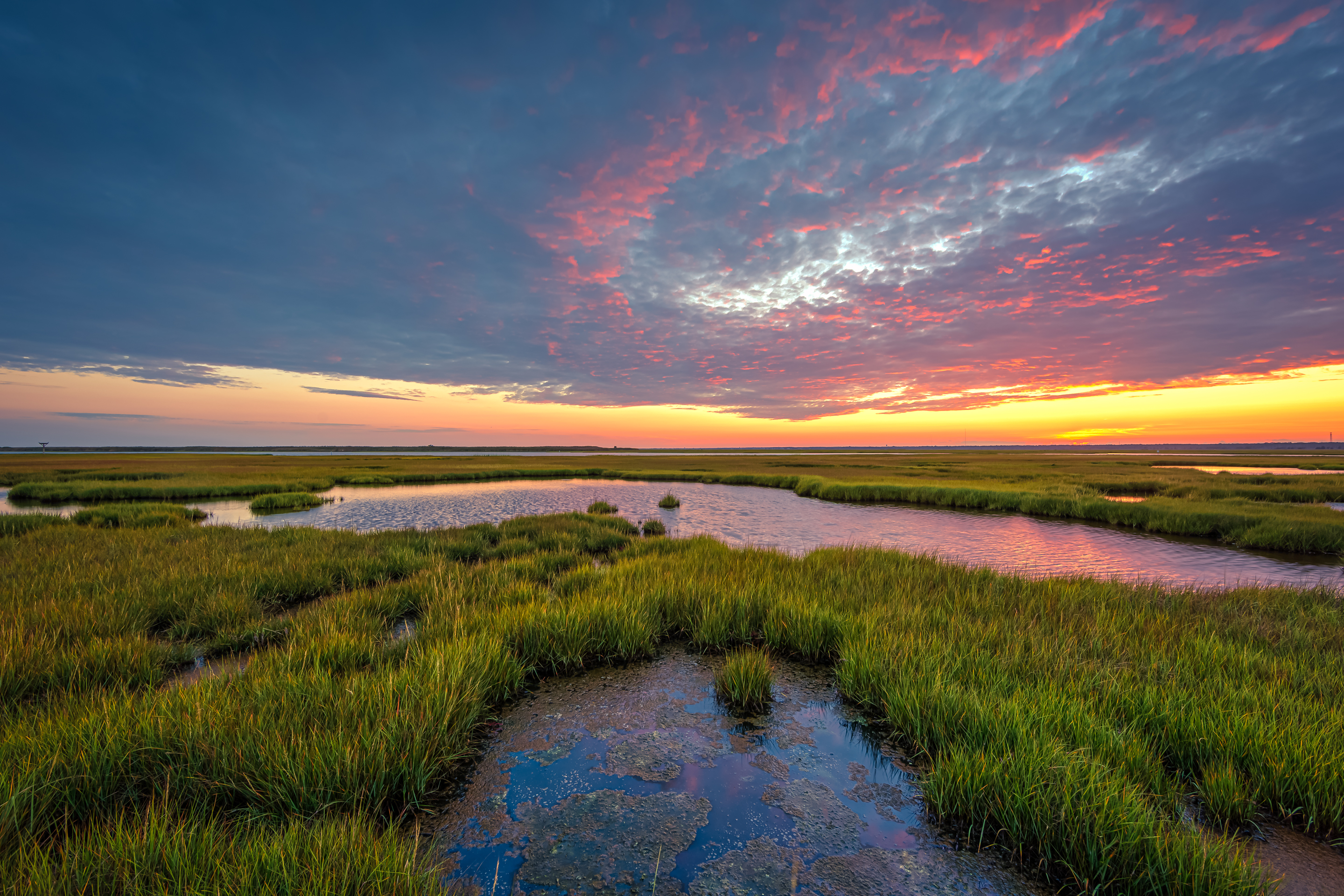 14mm wide angle HDR photo of Cedar Run Dock Road salt marsh right at sunset. Pink tones kiss a low level cloud deck to color up the sky.