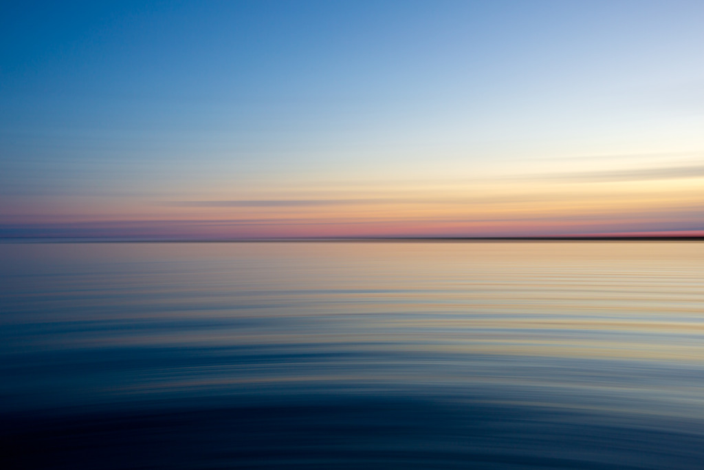 35mm blue hour photo with motion blur and slow shutter speeds bringing paint brush movement to the shimmering bay water and soothing skies.