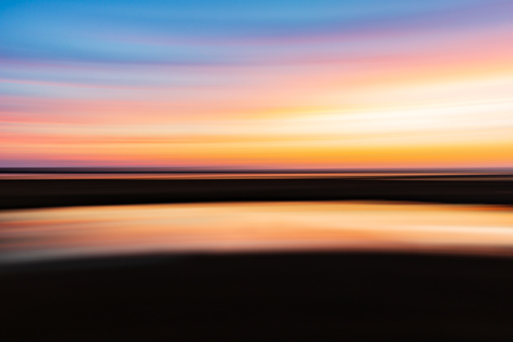 35mm motion blur sunset photo of New Jersey salt marsh in autumn. Panning creates a left to right streak blurred abstraction of Samus Aran's shinespark racing across the sky.