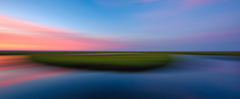14mm sunset photo at Cedar Run Dock Road's lush green salt marsh. Left to right panning introduces motion blur to the photograph rendering a dreamy, painterly effect to the image.