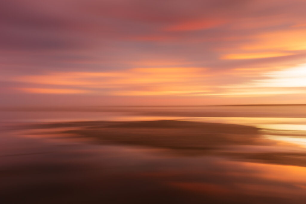 Soothing pastel colors pop up at a bayside sunset. Photographed at 35mm with motion blur created by intentional handheld left to right movement.