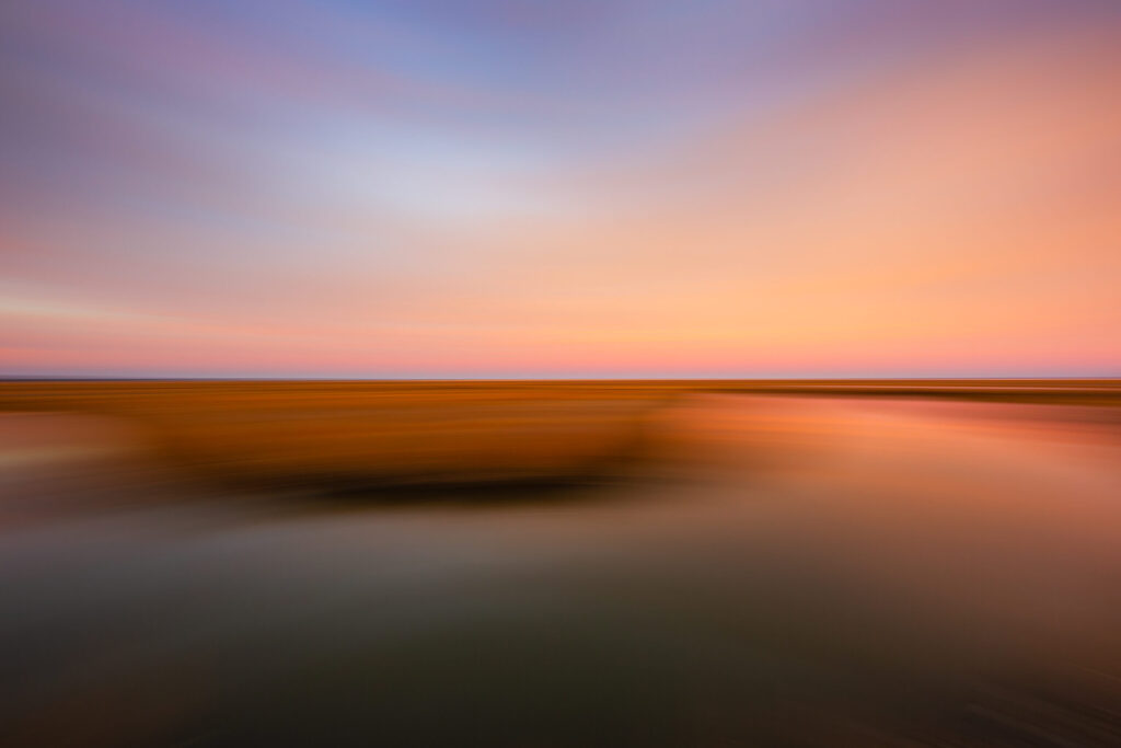 14mm salt marsh sunset photo with horizontal motion blur giving a painterly effect.